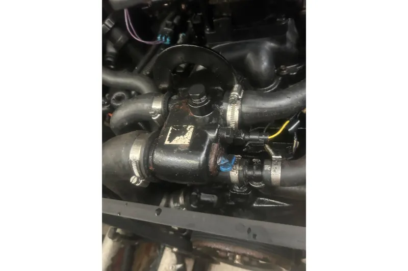 Slide: The Image of Engine components of a 2006 Sea Ray 300 Sundancer boat, featuring hoses and clamps. - 19