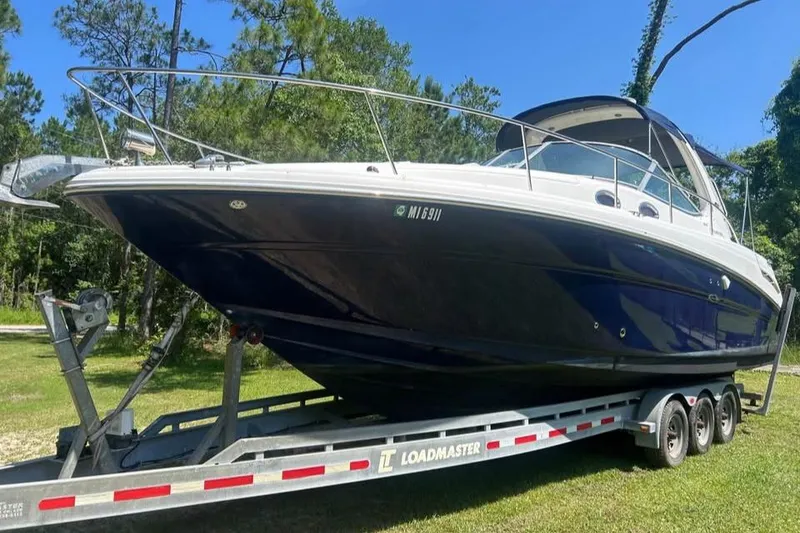 Slide: The Image of 2006 Sea Ray 300 Sundancer boat on trailer in a grassy area. - 28