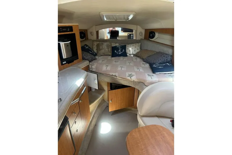 Slide: The Image of 2006 Sea Ray 300 Sundancer cabin interior with bed, kitchenette, and seating area. - 29