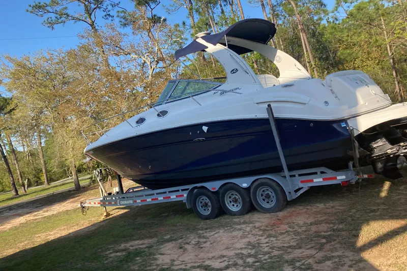 Slide: The Image of 2006 Sea Ray 300 Sundancer boat on trailer, parked in a wooded area. - 35