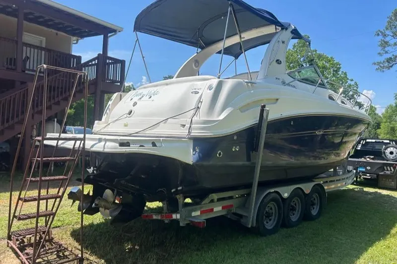 Slide: The Image of 2006 Sea Ray 300 Sundancer boat on trailer, parked outdoors under blue sky. - 4
