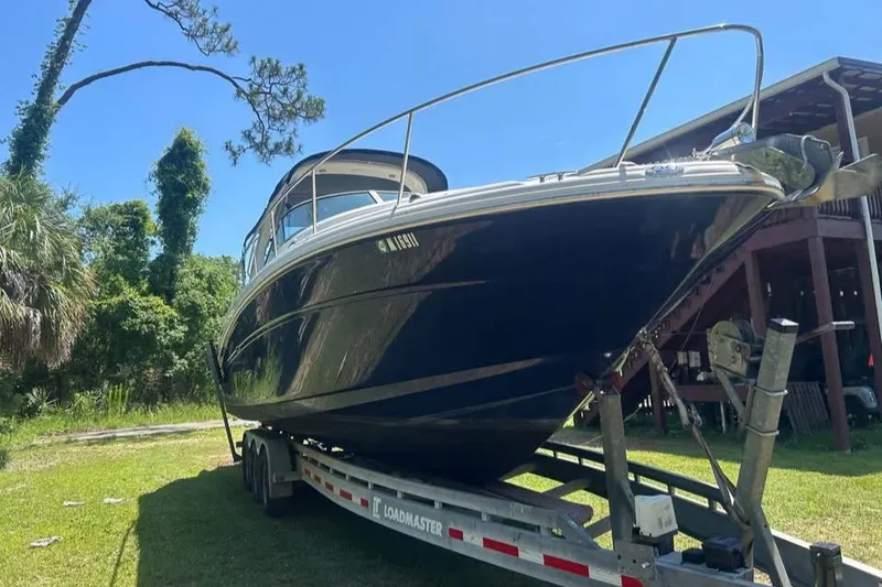Slide: The Image of 2006 Sea Ray 300 Sundancer boat on trailer, parked outdoors under clear blue sky. - 5