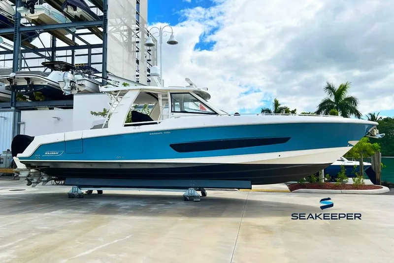 The Image of 2018 Boston Whaler 420 Outrage boat displayed on a dock with palm trees in the background. - 0