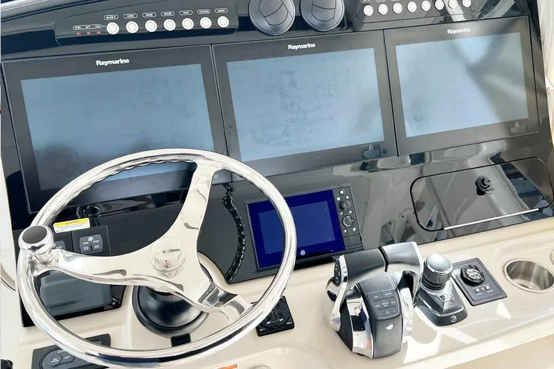 Slide: The Image of Control panel of 2018 Boston Whaler 420 Outrage with Raymarine displays and steering wheel. - 10