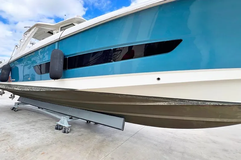 Slide: The Image of 2018 Boston Whaler 420 Outrage boat on trailer, blue hull, docked outdoors. - 26