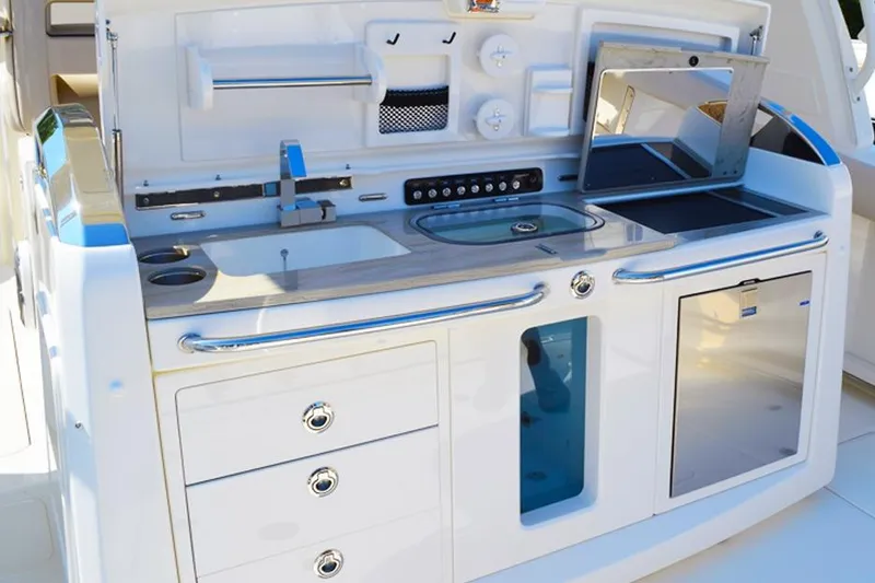 Slide: The Image of 2018 Boston Whaler 420 Outrage boat kitchen with sink, storage, and modern amenities. - 8