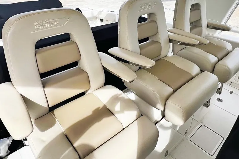 Slide: The Image of Luxurious seating on a 2018 Boston Whaler 420 Outrage boat, featuring plush beige upholstery. - 9