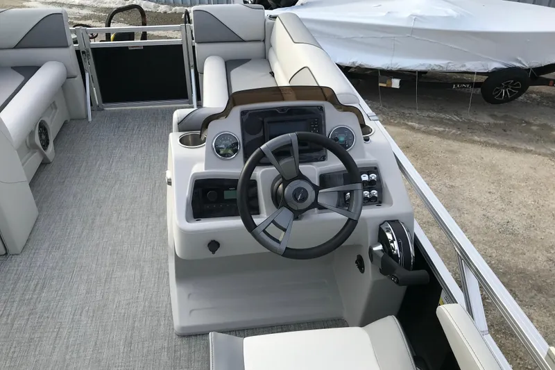 Slide: The Image of 2026 Avalon Venture Cruise Rear Bench boat interior with steering console and seating. - 13
