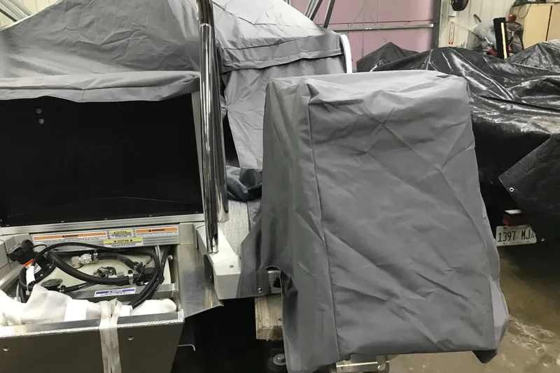 Slide: The Image of 2026 Avalon Venture Cruise Rear Bench covered in gray tarp in a garage. - 18