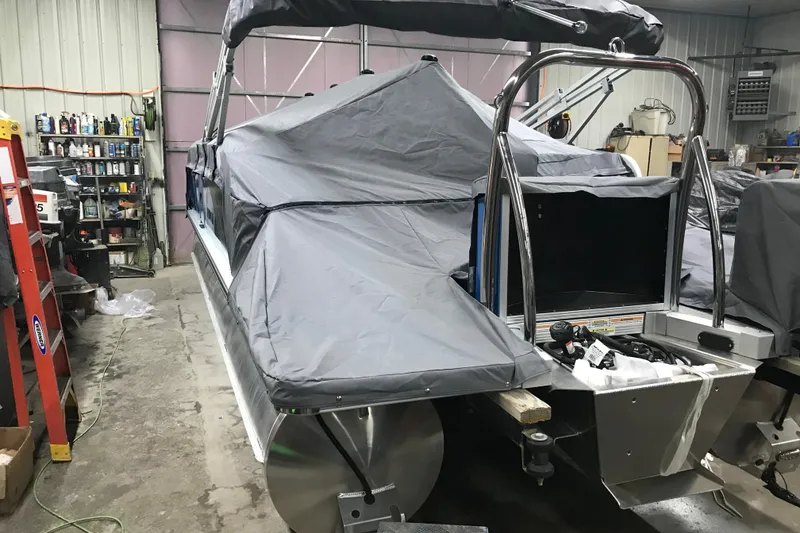 Slide: The Image of 2026 Avalon Venture Cruise Rear Bench boat covered in a garage setting. - 19