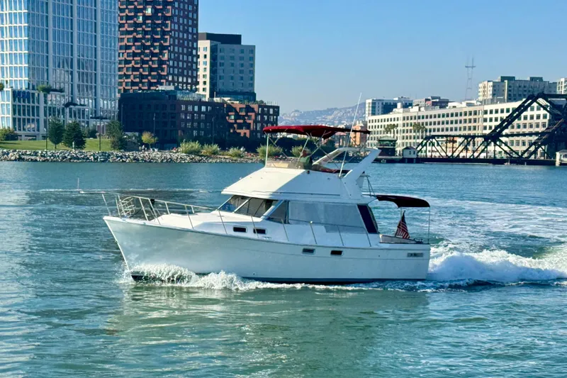The Image of 1989 Bayliner 3288 Motoryacht cruising in urban waterfront setting. - 1