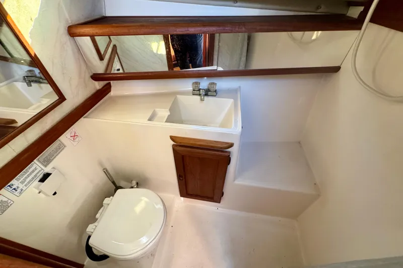Slide: The Image of 1989 Bayliner 3288 Motoryacht bathroom with sink, toilet, and wooden accents. - 11