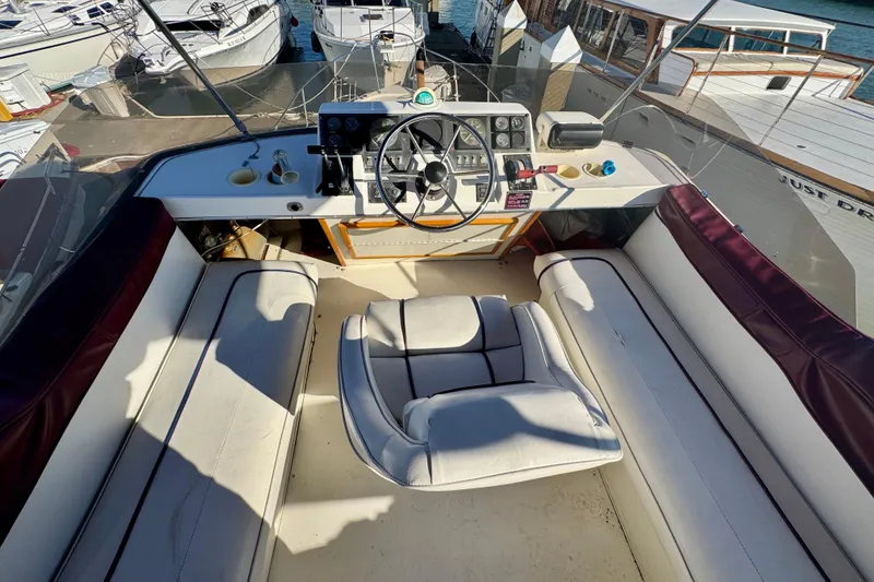 Slide: The Image of 1989 Bayliner 3288 Motoryacht cockpit with steering wheel and seating, docked at marina. - 14