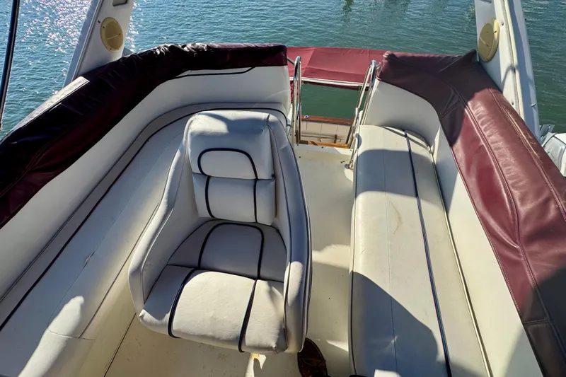 Slide: The Image of 1989 Bayliner 3288 Motoryacht interior with white and maroon seating, overlooking water. - 15
