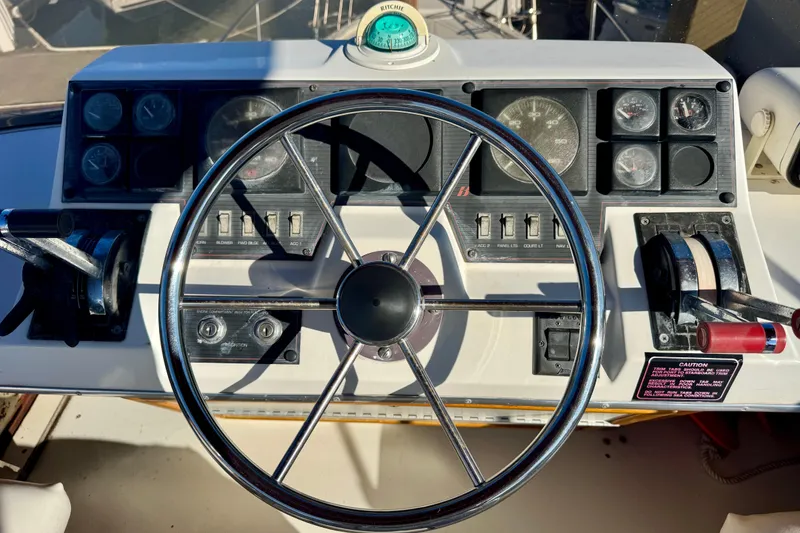Slide: The Image of 1989 Bayliner 3288 Motoryacht helm with steering wheel and control panel. - 16