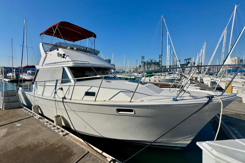 Slide: The Image of 1989 Bayliner 3288 Motoryacht docked at marina under clear blue sky. - 19
