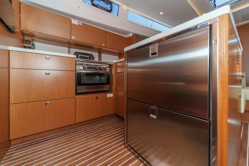 Slide: The Image of Modern kitchen in 2023 Bavaria C50 yacht with wood cabinetry and stainless steel appliances. - 38