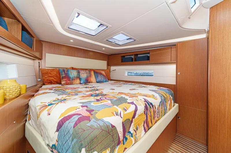 Slide: The Image of Luxurious 2023 Bavaria C50 yacht cabin with colorful bedding and modern wood finishes. - 55