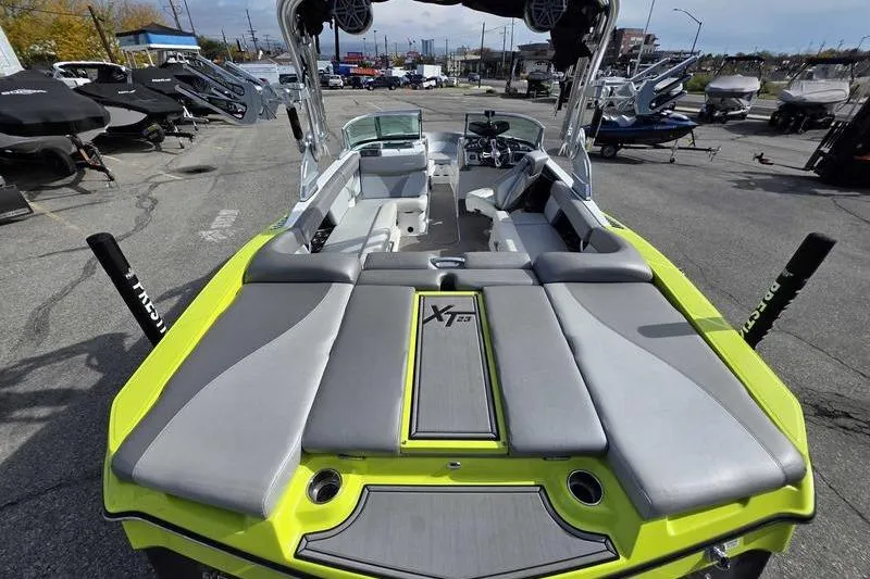 Slide: The Image of 2017 MasterCraft XT23 boat with gray and yellow seating, parked in a marina. - 10
