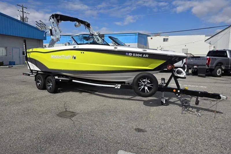 Slide: The Image of 2017 MasterCraft XT23 boat interior with gray and white seating, cup holders, and steering wheel. - 3