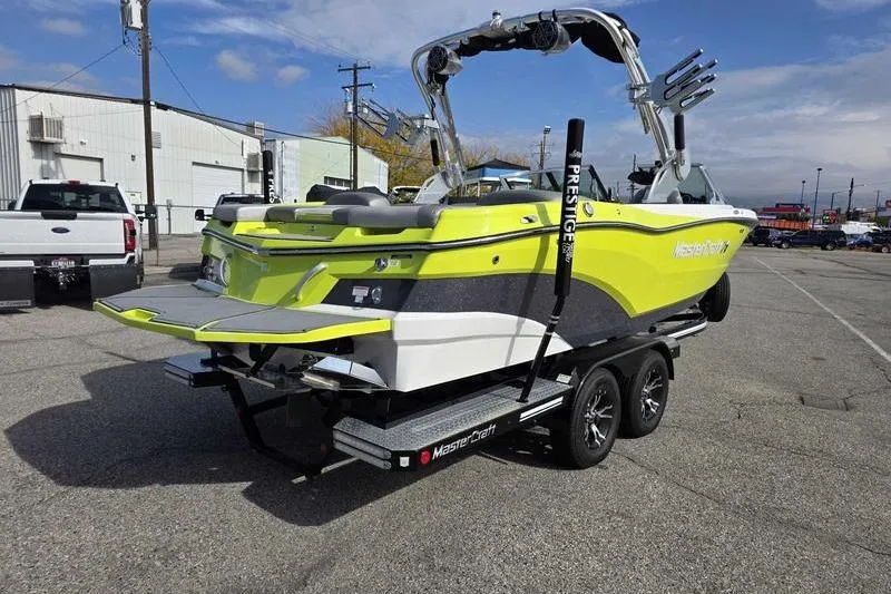 Slide: The Image of 2017 MasterCraft XT23 boat on trailer, vibrant yellow and black design, parked outdoors. - 4
