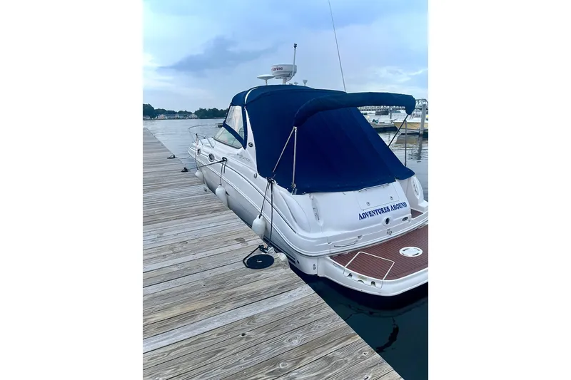 Slide: The Image of 2007 Sea Ray 280 Sundancer docked with blue canopy, wooden deck, and calm waters. - 3