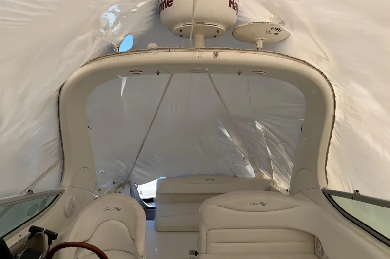 Slide: The Image of 2007 Sea Ray Sundancer 280 interior under protective cover, showcasing seating and helm. - 12