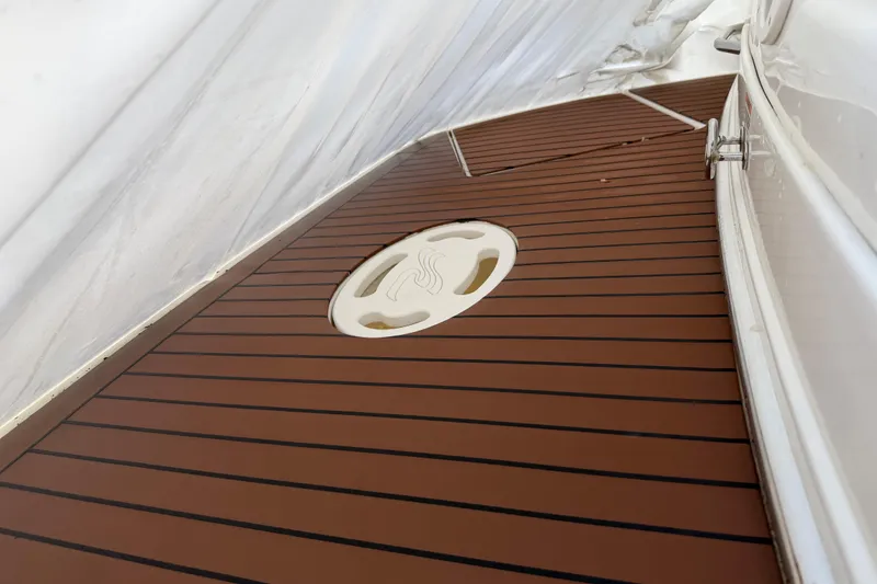 Slide: The Image of 2007 Sea Ray Sundancer 280 boat deck with teak flooring and circular hatch. - 19