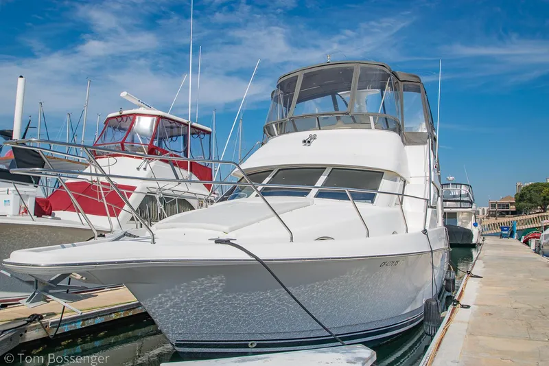 Slide: The Image of 1996 Silverton 372 Motor Yacht docked at marina under clear blue sky. - 0