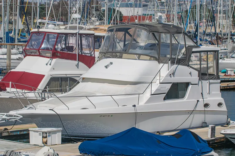 Slide: The Image of 1996 Silverton 372 Motor Yacht docked at a marina, surrounded by other boats. - 1