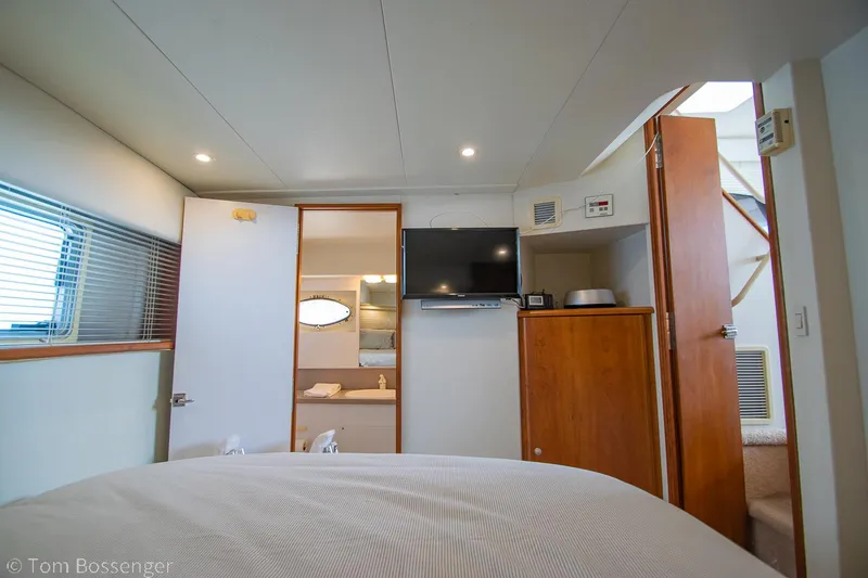 Slide: The Image of Interior of 1996 Silverton 372 Motor Yacht bedroom with TV and wooden cabinetry. - 21