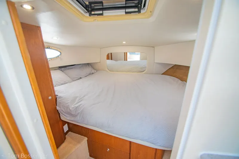Slide: The Image of 1996 Silverton 372 Motor Yacht cabin with cozy bed and wooden storage. - 24