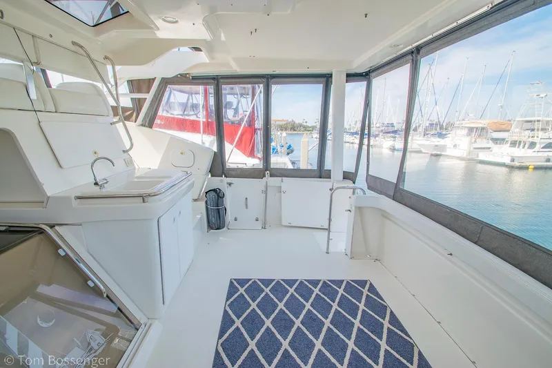 Slide: The Image of 1996 Silverton 372 Motor Yacht interior with marina view, featuring a spacious, sunlit cabin. - 30