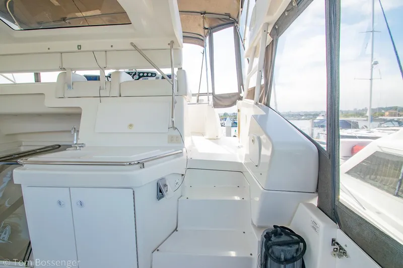 Slide: The Image of 1996 Silverton 372 Motor Yacht interior with white seating and steps, docked at marina. - 34