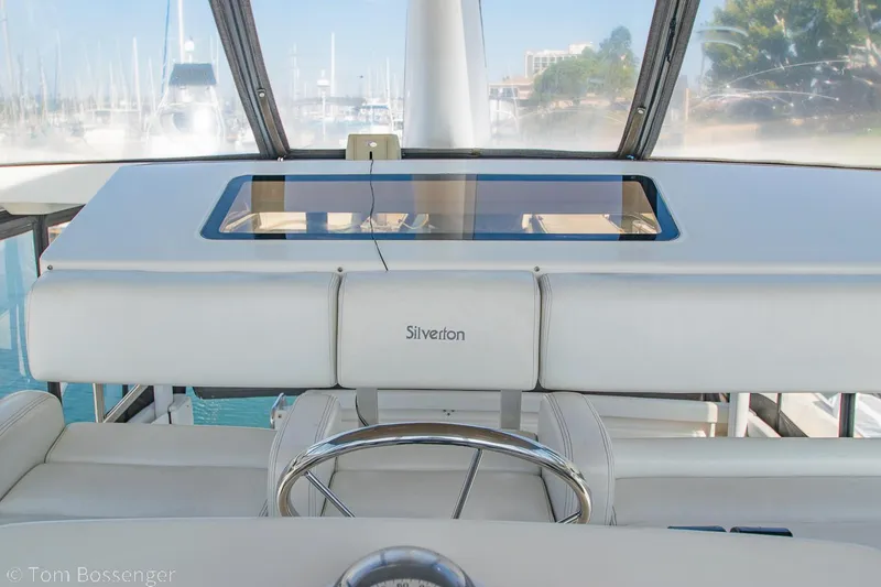 Slide: The Image of 1996 Silverton 372 Motor Yacht helm with steering wheel and dashboard view. - 36
