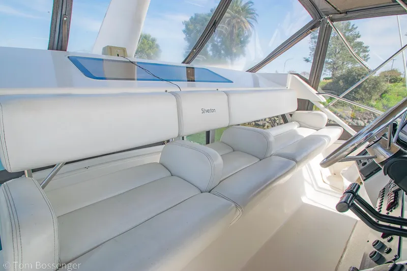 Slide: The Image of 1996 Silverton 372 Motor Yacht interior with white seating and steering wheel. - 37