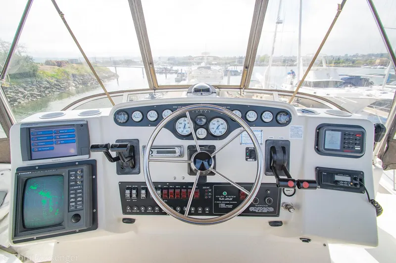 Slide: The Image of 1996 Silverton 372 Motor Yacht helm with navigation instruments and steering wheel. - 38