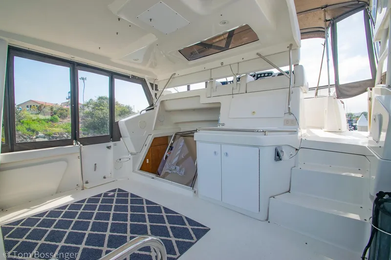 Slide: The Image of 1996 Silverton 372 Motor Yacht interior with seating, windows, and carpeted floor. - 5