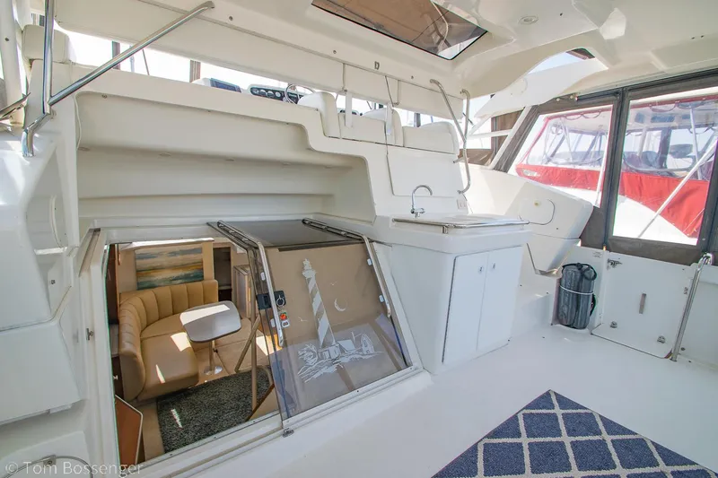 Slide: The Image of 1996 Silverton 372 Motor Yacht interior with open hatch, seating, and kitchenette. - 6