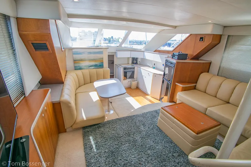Slide: The Image of 1996 Silverton 372 Motor Yacht interior with beige seating, kitchenette, and large windows. - 7