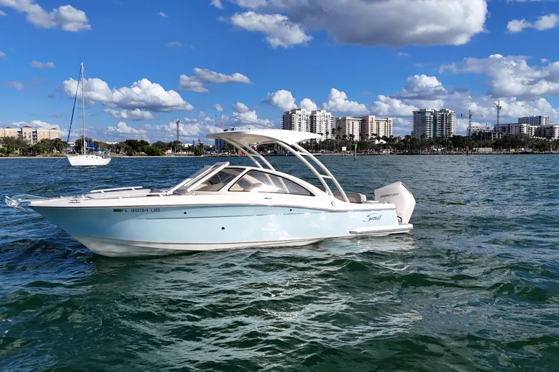 Slide: The Image of 2024 Scout 240 Dorado boat on water with city skyline in background. - 1