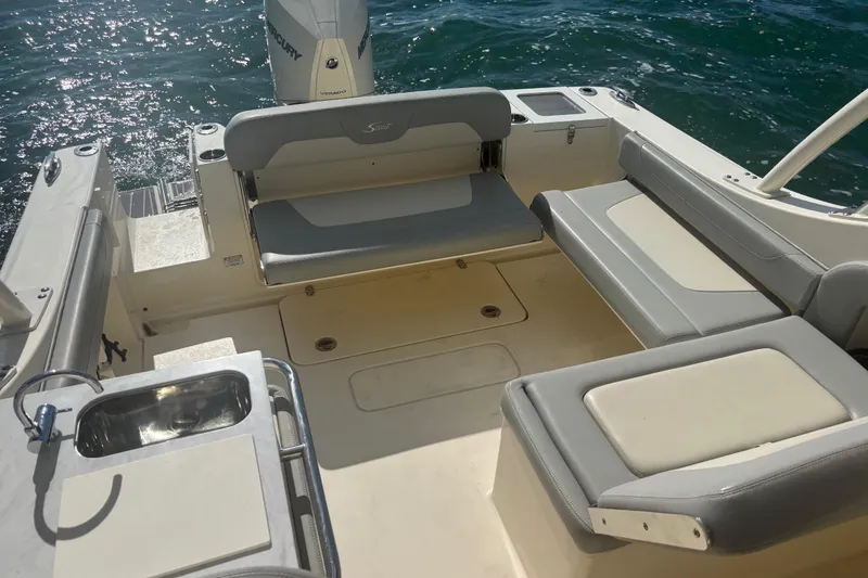 Slide: The Image of 2024 Scout 240 Dorado boat interior with seating and sink, on water. - 11