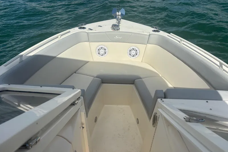 Slide: The Image of 2024 Scout 240 Dorado boat interior with cushioned seating and ocean view. - 16