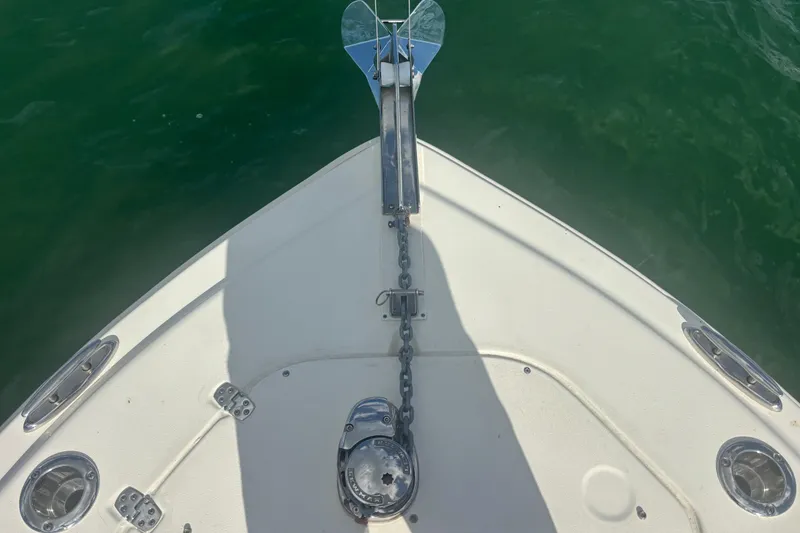 Slide: The Image of Bow of 2024 Scout 240 Dorado boat with anchor chain over green water. - 18