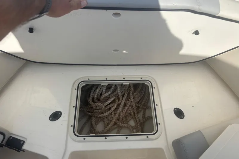 Slide: The Image of 2024 Scout 240 Dorado boat storage compartment with coiled rope inside. - 19