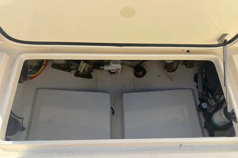 Slide: The Image of Open storage compartment of 2024 Scout 240 Dorado boat, showing internal components and wiring. - 23