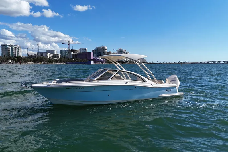 Slide: The Image of 2024 Scout 240 Dorado boat cruising on water with city skyline in background. - 4