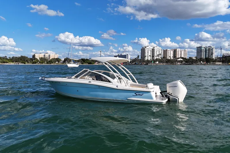 Slide: The Image of 2024 Scout 240 Dorado boat on water with city skyline in background. - 6
