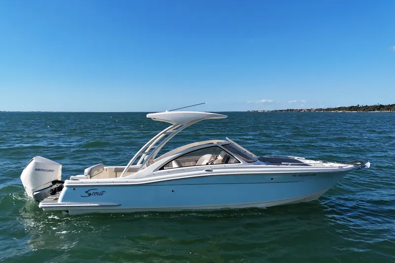Slide: The Image of 2024 Scout 240 Dorado boat cruising on open water under clear blue sky. - 9