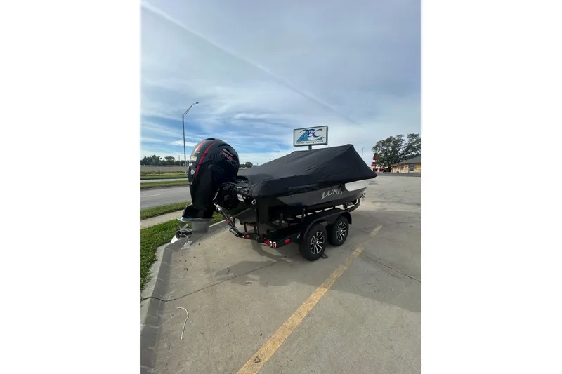 Slide: The Image of 2026 Lund 185 Impact GL boat on trailer, covered, parked in lot. - 10